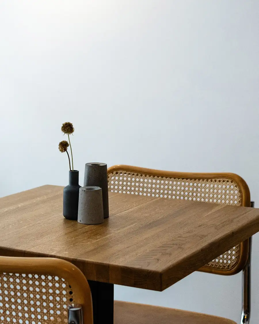Mesa de madera con silla de rejilla y luz natural suave